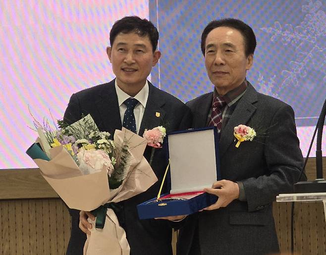 윤성원 제38대 한남대 총동문회장이 박영진 전 총동문회장에게 감사패와 꽃다발을 전달하고 있다.