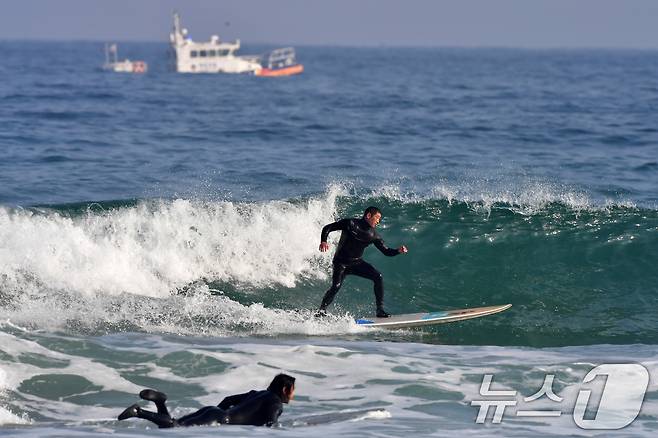 18일 경북 포항시 북구 흥해읍 용한리 해수욕장에서 서퍼들이 겨울 파도를 타고 있는 가운데 포항해양경찰서 연안구조정이 연안 순찰을 하고 있다. 2026.1.18/뉴스1 ⓒ News1 최창호 기자
