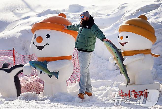 18일 강원도 평창군 진부면 오대천 일원에 열린 평창송어축제를 찾은 외국인 방문객이 눈동이 조각을 배경으로 기념사진을 촬영하고 있다. (평창군 제공. 재판매 및 DB 금지) 2026.1.18/뉴스1