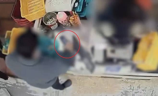 The suspect in a knife attack at a motel in Changwon, South Gyeongsang, buys the weapon used in the crime, circled in red, at a nearby mart just before entering the motel on Dec. 3. [SCREEN CAPTURE]