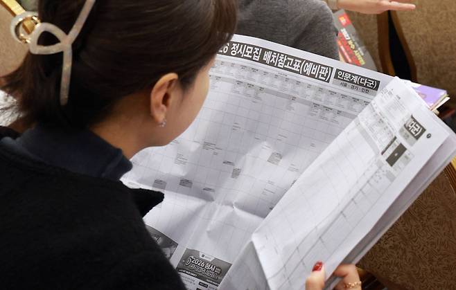 지난해 11월 14일 서울 광진구 세종대학교에서 열린 종로학원 2026 정시 합격예측 및 전략 설명회에서 학부모들이 배치참고표를 보고 있다. [연합뉴스]