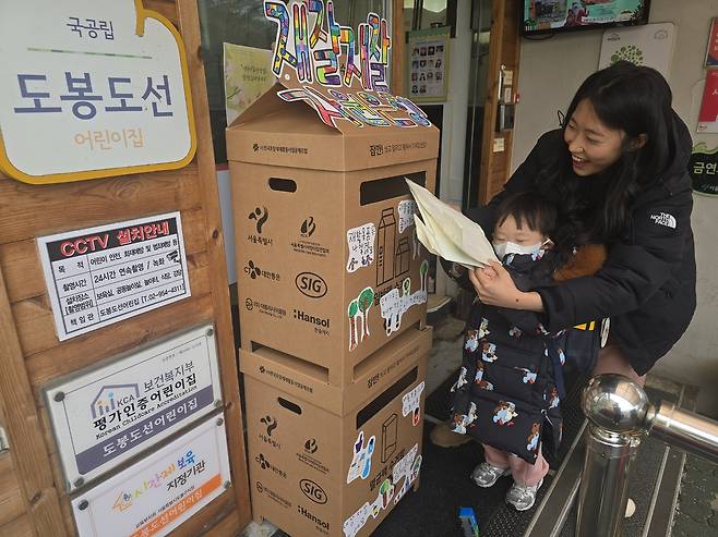 도봉도선어린이집 어린이와 부모가 집에서 가져온 종이팩을 수거함에 넣고 있다. [도봉도선어린이집 제공]
