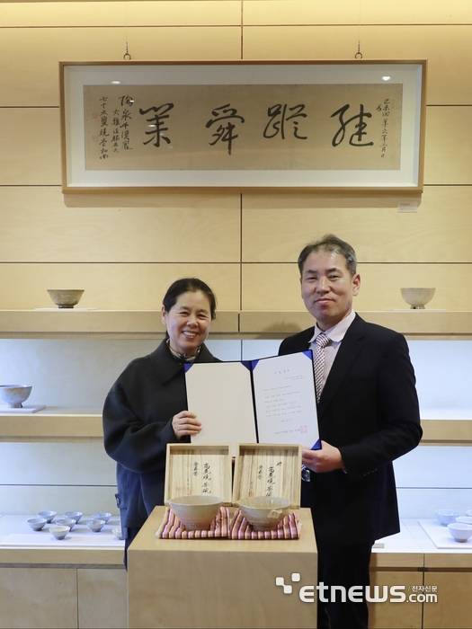 김상현 오킨스전자 부사장(오른쪽)과 천경희  도천도자미술관 대표가 기증서를 펼쳐 보이고 있다.