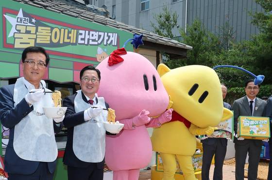 대전시가 ‘대전 꿈돌이 라면’을 공식 출시한 가운데 대전 동구 꿈돌이네 라면가게에서 이장우 대전시장이 현판식을 마치고 퍼포먼스를 하고 있다. '대전 꿈돌이 라면’'은 대전을 대표하는 캐릭터 ‘꿈돌이’를 활용한 전국 최초의 캐릭터 라면으로 쇠고기맛과 해물짬뽕맛 2종으로 구성돼 있다. 가격은 개당 1500원이며, 대전역 3층 ‘꿈돌이와 대전여행’, 꿈돌이하우스, 트래블라운지, 신세계백화점 대전홍보관, GS25, 농협 하나로마트 등 대전 주요 판매처에서 구입할 수 있다. 뉴스1