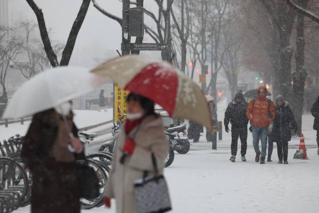 ▲ 서울 종로구 종각역 인근에서 시민들이 눈을 맞으며 이동하고 있다. 연합뉴스