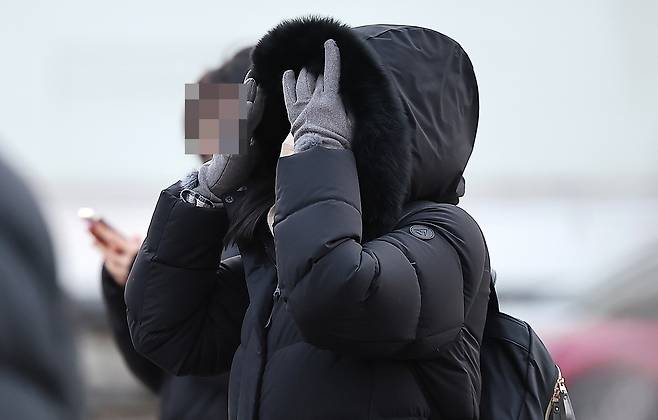 A pedestrian walks across the Gwanghwamun Square in central Seoul with a thick coat and gloves, on Jan. 5. [NEWS1]