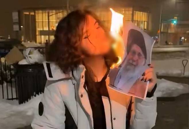 이란 최고지도자 사진을 담뱃불로 사용하는 이란 여성. [사진출처 = SNS]