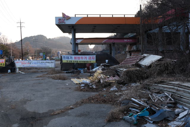 18일 경기 남양주시 경춘로 한 폐주유소에 목재 등 각종 폐기물이 쌓인 채 방치돼 있다. 남양주=황동건 기자