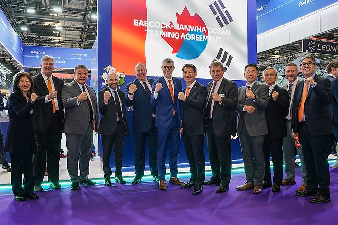 Hanwha Ocean Vice President and Head of Special Ship Overseas Business Jung Seung-gyun (sixth from right) and officials from Hanwha Ocean and Babcock pose for a photo during a signing ceremony on Tuesday. (Hanwha Ocean)