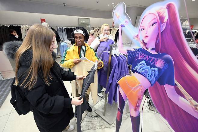 Foreign tourists take a look at clothes collaborated with Netflix's "KPop Demon Hunters" (2025) at a store in Myeong-dong in central Seoul in December, 2025. [YONHAP]