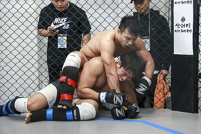 ‘수원 들소’ 김영훈이 챔피언으로 참가한 KMMA 라이트헤비급 타이틀 1차 방어전에서 도전자 ‘썬더스톰’ 박준현을 그라운드 앤드 파운드로 공격하고 있다. 사진=뽀빠이연합의원KMMA파이터에이전시 제공