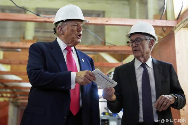 [워싱턴=AP/뉴시스] 도널드 트럼프(왼쪽) 미국 대통령이 24일(현지 시간) 워싱턴DC 연방준비제도(연준) 건물 개보수 현장을 방문해 제롬 파월 의장에게 비용 관련 문서를 건네고 있다. 트럼프 대통령은 파월 의장 면전에서 금리 인하를 촉구했다. 2025.07.25. /사진=민경찬