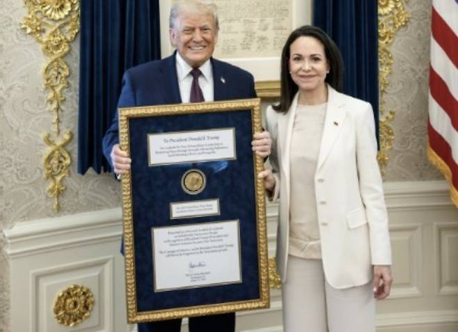 마차도로부터 노벨평화상 메달 담긴 대형 금색 액자 전달받은 트럼프 대통령. 연합뉴스