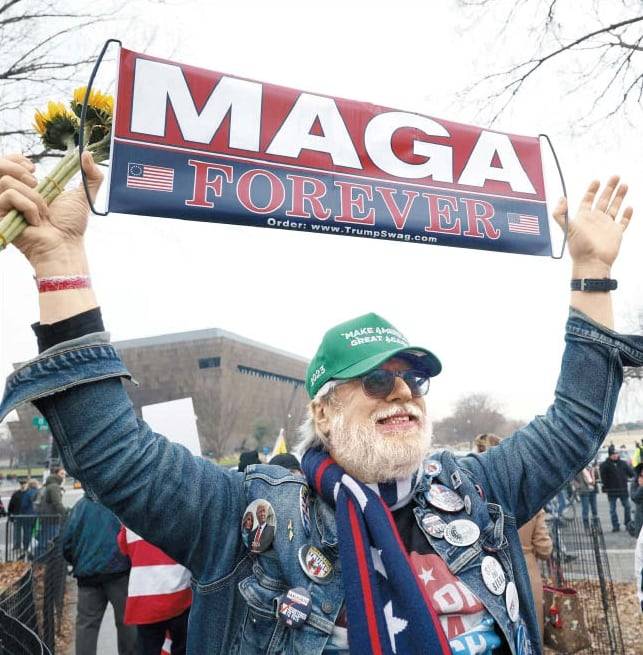 지난 6일 워싱턴 DC에서 열린 ‘1·6 의회 폭동’ 기념 행사에서 트럼프 지지자가 ‘매가(MAGA)여 영원하라’ 플래카드를 들고 행진하고 있다. /AFP 연합뉴스