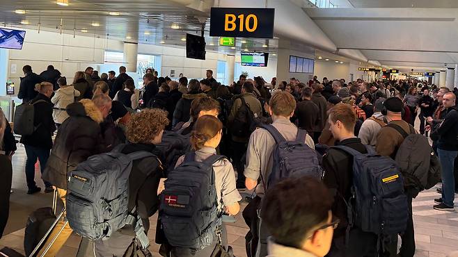 ‘뜨거운 그린란드’… 여객기 연일 꽉 차. 20일 덴마크 코펜하겐에서 그린란드 수도 누크로 향하는 여객기 탑승구가 가방에 국기를 부착한 소방관 등 승객들로 붐비고 있다. 그린란드를 둘러싼 덴마크와 미국의 갈등이 고조되면서 안보 당국자와 취재진 등 그린란드행 승객도 최근 크게 늘었다./코펜하겐=원선우 특파원