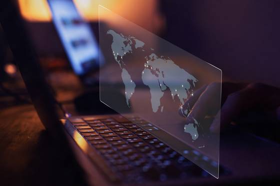 A virtual screen shows dots on the world map. [GETTY IMAGES BANK]