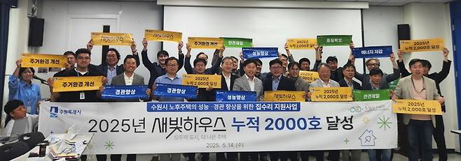 수원시의 노후 저층주택 주거 환경 개선 사업인 '새빛하우스' 지원 누적 2천 호를 달성한 지난해 5월 관계자들이 기념 촬영을 하고 있다. 사진=수원도시재단