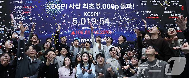 22일 서울 중구 우리은행 본점 딜링룸에서 직원들이 장중 최고가가 찍힌 전광판을 배경으로 코스피 5000 돌파를 축하하고 있다. 2026.1.22/뉴스1 ⓒ News1 오대일 기자