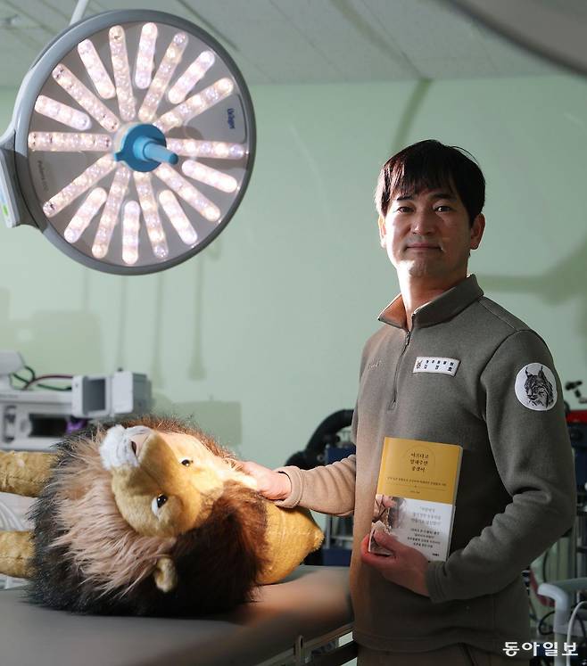 19일 충북 청주시 청주동물원 동물병원에서 만난 김정호 수의사가 평소 병원에 전시하는 사자 인형을 수술대 옆에서 어루만지고 있다. 그는 이 수술대에서 ‘갈비 사자’로 유명한 바람이의 딸 구름이를 수술하기도 했다. 청주=신원건 기자 laputa@donga.com