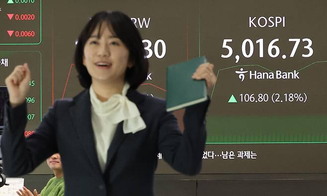 코스피가 장중 5,000을 넘어선 가운데 22일 오전 서울 중구 하나은행 딜링룸에서 딜러가 환호하고 있다. 연합뉴스