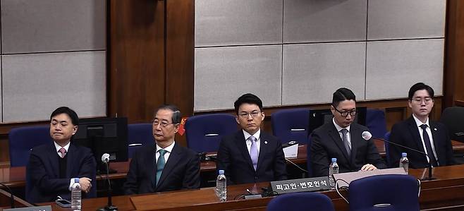 내란 중요임무 종사 혐의 등으로 기소된 한덕수 전 국무총리(왼쪽 둘째)가 21일 서울중앙지방법원에서 열린 1심 선고 공판에 출석해 있다. [연합뉴스]