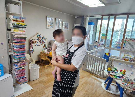 A Filipino caregiver holds a baby at a household in Seoul on Sept. 3. [SEOUL METROPOLITAN GOVERNMENT]