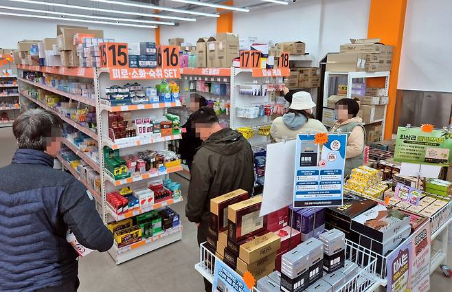 Customers consult a pharmacist while purchasing medicine at a warehouse-style pharmacy in Ssangchon-dong, Seo District, Gwangju, on Jan. 18. [HWANG HEE-GYU]