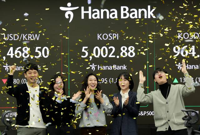 코스피가 장중 5,000을 넘어선 가운데 22일 오전 서울 중구 하나은행 딜링룸에서 외환 딜러들이 세리머니를 펼치고 있다. 연합뉴스