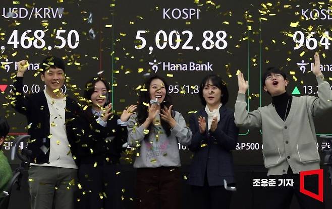 코스피가 꿈의 지수 '5000'을 돌파한 22일 서울 중구 하나은행 딜링룸에서 직원들이 기뻐하며 박수를 치고 있다. 2026.1.22 조용준 기자