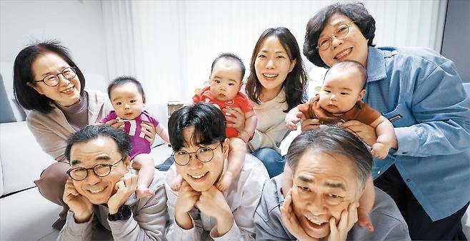 세 쌍둥이를 키우는 심여진·박현재(가운데)씨 부부가 18일 친조부모인 박정원·유영희(왼쪽)씨, 외조부모 심재곤·이경희(오른쪽)씨와 함께 활짝 웃고 있다./박성원 기자