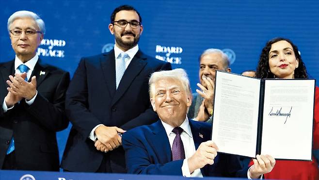 도널드 트럼프 미국 대통령이 22일 스위스 다보스 세계경제포럼(WEF) 연차총회에서 평화위원회(Board of Peace) 창설 헌장에 서명한 뒤 이를 들어 보이고 있다./AP 연합뉴스