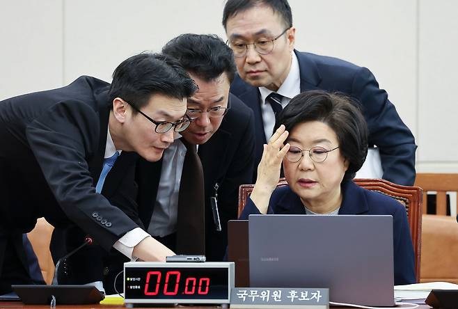 Lee Hye-hoon, the nominee as the first minister of the to-be-established Ministry of Planning and Budget, sitting, is seen speaking with officials during her confirmation hearing at the National Assembly in Yeouido, western Seoul, on Jan. 23. [NEWS1]