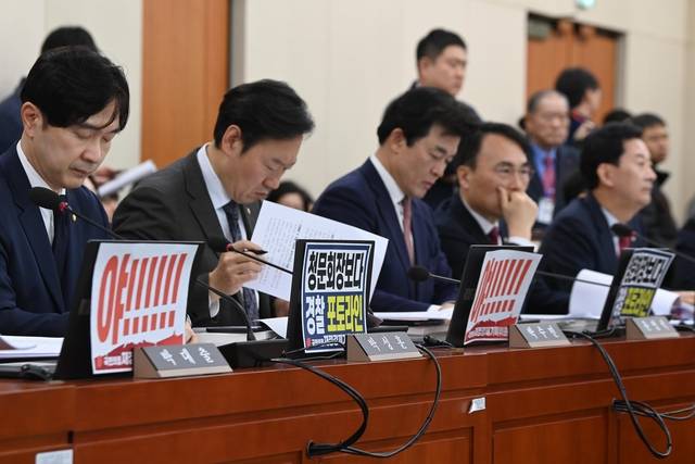 野 “李, 경찰포토라인 서야” : 23일 오전 국회 재정경제기획위원회 이혜훈 기획예산처 장관 후보자 인사청문회가 열리기 전 국민의힘 의원들이 이 후보자를 비판하는 피켓을 세워 놓은 채 자료를 검토하고 있다. 문호남 기자