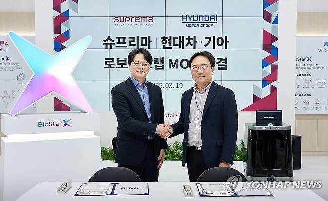현대차·기아, 슈프리마와 로봇 친화 빌딩 확대를 위한 업무협약 체결 (서울=연합뉴스) 현동진 현대차·기아 로보틱스랩장 상무(오른쪽)가 지난 19일 경기 고양시 킨텍스에서 국내 보안시스템 전문업체 슈프리마와 로봇 친화 빌딩 구축 확대를 위해 '로보틱스 및 AI 기반 토탈 보안 설루션 구축 사업에 관한 업무협약을 체결한 후 김한철 슈프리마 대표와 기념 촬영하고 있다. 2025.3.20 [현대자동차·기아 제공. 재판매 및 DB 금지] photo@yna.co.kr