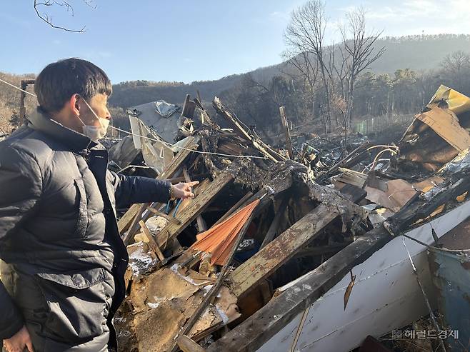 20일 구룡마을 4지구의 한 이재민이 불 타 없어진 자신의 집터를 가리키며 설명하는 모습. 정주원 기자