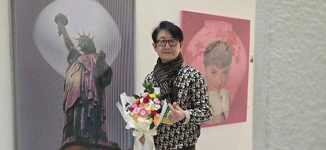 서울 코엑스에서 열린 아트페스타에서 만난 김중식 작가가 그의 작품들 앞에서 포즈를 취하고 있다.                                                               사진 한성일 기자