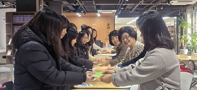 호수돈총동문회 임원들이 졸업생 대표들에게 기념품을 전달하고 있다.