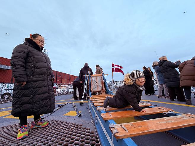 24일 그린란드 누크항에 정박한 덴마크 해군 호위함 HDMS 베데렌(Vædderen·F359)호 갑판에서 한 어린이가 개썰매에 올라 놀고 있다./원선우 특파원