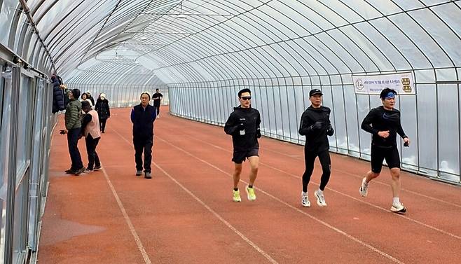 지난 18일 오후 경기 포천시 군내면 구읍리 포천종합운동장 육상 트랙의 모습. 비닐 구조물을 덧씌운 트랙 위를 시민들이 각자의 방식으로 달리거나 산책하면서 이용하고 있다.