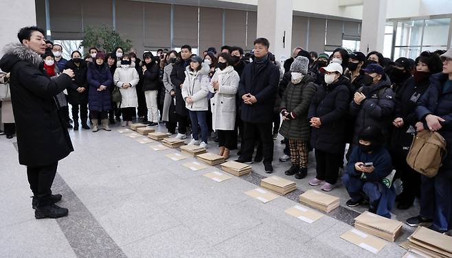 홍콩지수 ELS 피해자 모임 관계자들이 국회 소통관에서 국회의원들에게 보낼 탄원서를 앞에 두고 대화하는 모습. [한주형 기자]