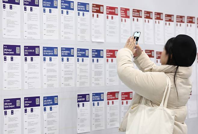 지난 11일 서울 강남구 코엑스에서 열린 ‘2026 스타트업 채용박람회’를 찾은 구직자가 채용공고 게시대를 살펴보고 있다. [연합뉴스]