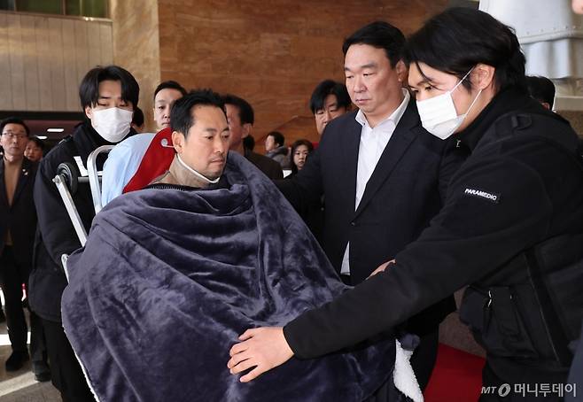 (서울=뉴스1) 국회사진기자단 = '통일교·공천헌금' 쌍특검법 수용을 촉구하며 단식을 시작한 장동혁 국민의힘 대표가 22일 서울 여의도 국회에서 단식 8일 만에 박근혜 전 대통령의 단식 중단 권고를 받아들여 병원으로 이송되고 있다. 2026.1.22/뉴스1  Copyright (C) 뉴스1. All rights reserved. 무단 전재 및 재배포,  AI학습 이용 금지. /사진=(서울=뉴스1) 국회사진기자단