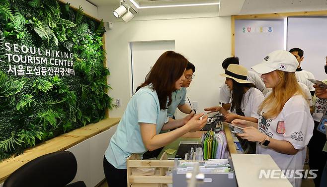 [서울=뉴시스] 김근수 기자 = 18일 서울 종로구 서울도심 등산관광센터 북악산점에서 외국인 관광객들이 등산코스 설명을 듣고 있다. 2024.04.18. ks@newsis.com