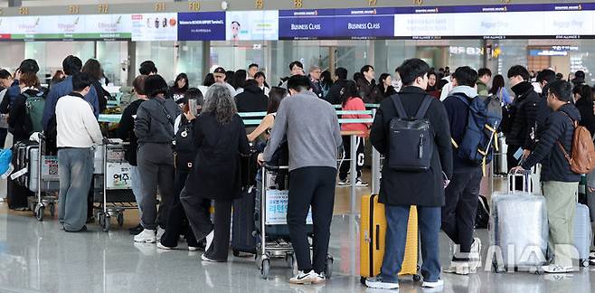 [인천공항=뉴시스] 이영환 기자 = 25일 오후 인천국제공항 제1여객터미널에서 여행객들이 출국 수속을 기다리고 있다.인천국제공항공사는 중국, 일본 노선 항공수요 증가세에 힘입어 2025년 여객실적 7407만 1475명, 운항실적 42만 5760회를 기록해 지난 2001년 개항이후 역대 최다 항공운송실적을 달성했다고 이날 밝혔다. 2026.01.25. 20hwan@newsis.com