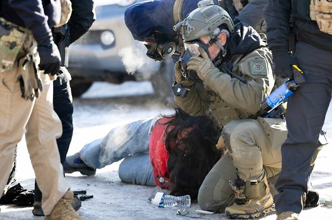 24일 토요일, 미니애폴리스에서 연방 요원들의 총격으로 사망한 알렉스 프레티(Alex Pretti·37)의 사건 현장 인근에서 한 시위자가 연행되고 있다. 2026.1.25. AP 연합뉴스