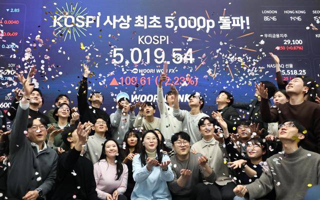 서울 중구 우리은행 본점 딜링룸에서 딜러들이 코스피 지수 5000선 돌파를 축하하고 있는 모습 [사진=연합뉴스]
