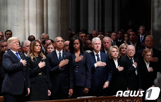 도널드 트럼프 미국 대통령과 부인 멜라니아 여사와 버락 오바마, 빌 클린턴, 지미 카터 등 전직 대통령 부부들이 5일 (현지시간) 워싱턴 국립성당에서 거행된 조지 H.W. 부시 전 미국 대통령의 국장에 참석해 손을 가슴에 얹고 조의를 표하고 있다. 2018.12.5 ⓒ AFP=뉴스1