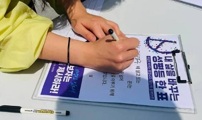 2025년 5월13일 한 유권자가 서울 서대문구 신촌역 인근에서 열린 ‘성평등 정치로 가는 페미니스트 공동행동’ 캠페인 선포식에서 성평등 투표 선언문을 작성하고 있다. 한국여성단체연합 제공