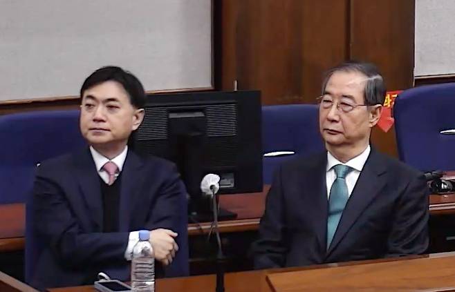 내란 중요임무 종사 혐의를 받는 한덕수 전 국무총리(왼쪽)가 21일 서울중앙지법에서 열린 1심 선고 공판에 출석해 있다. / 사진=서울중앙지법 제공