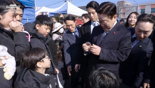 어린 아이에게 ‘두쫀쿠(두바이쫀득쿠키)’를 선물 받은 이재명 대통령. [이 대통령 유튜브 캡처]